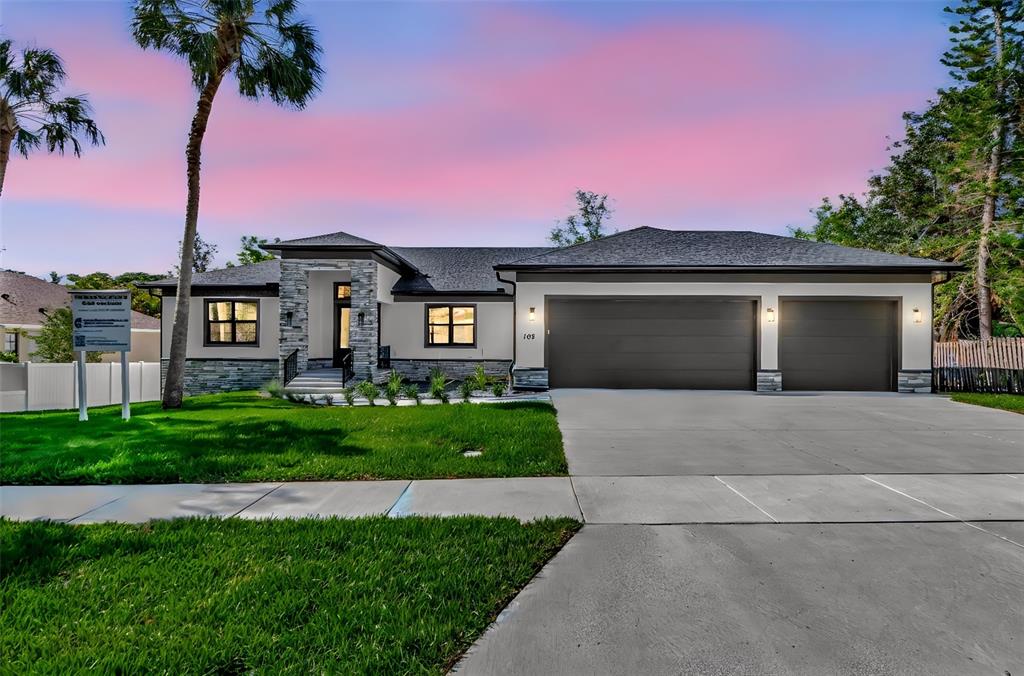 108 Irwin Street East Safety Harbor, FL 34695 - Photo 1 of 79 a front view of a house with a yard and garage