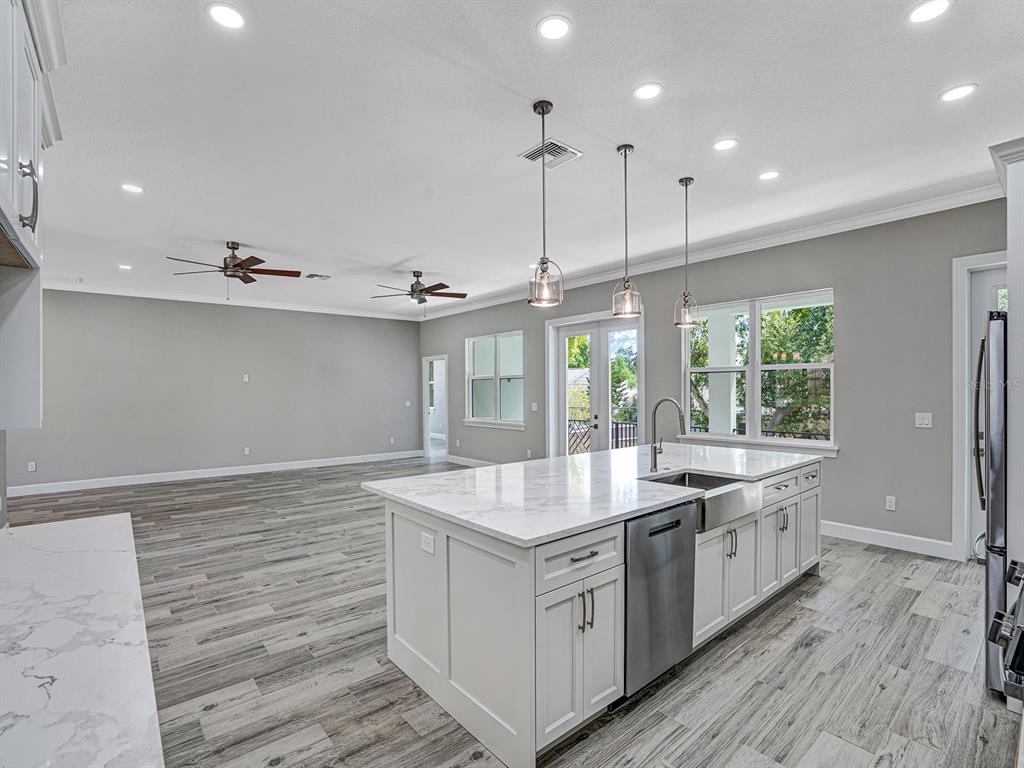 108 Irwin Street East Safety Harbor, FL 34695 - Photo 28 of 79 a large white kitchen with granite countertop a sink and dishwasher with wooden floor
