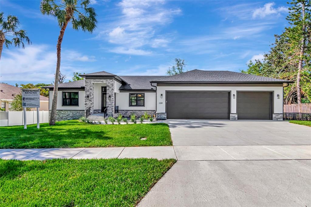 108 Irwin Street East Safety Harbor, FL 34695 - Photo 6 of 79 a front view of a house with a garden and yard