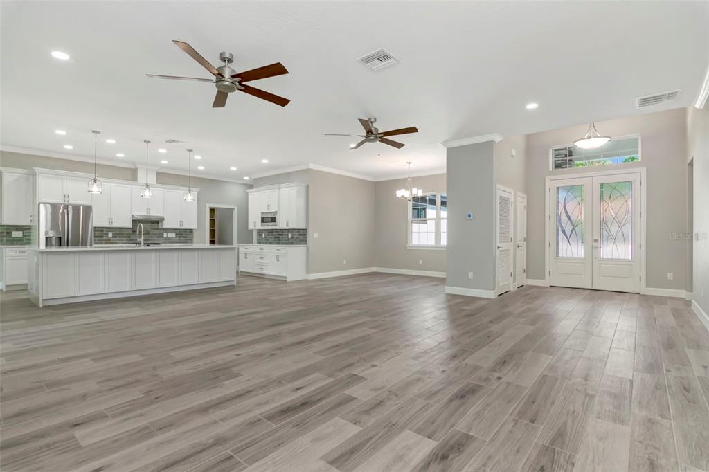 108 Irwin Street East Safety Harbor, FL 34695 - Photo 74 of 79 a view of an empty room with wooden floor and a kitchen