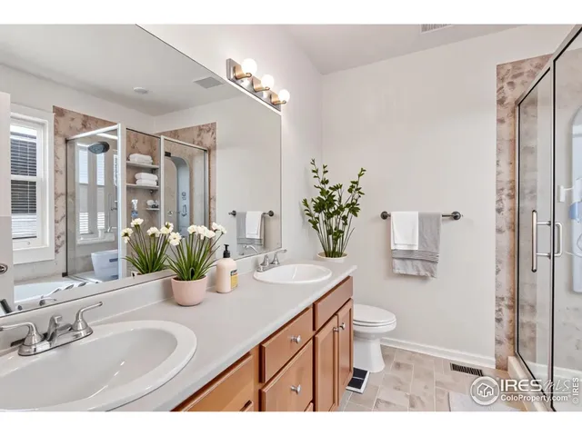 a bathroom with a granite countertop sink a toilet a mirror and shower