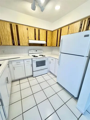 a kitchen with a refrigerator sink stove and cabinets