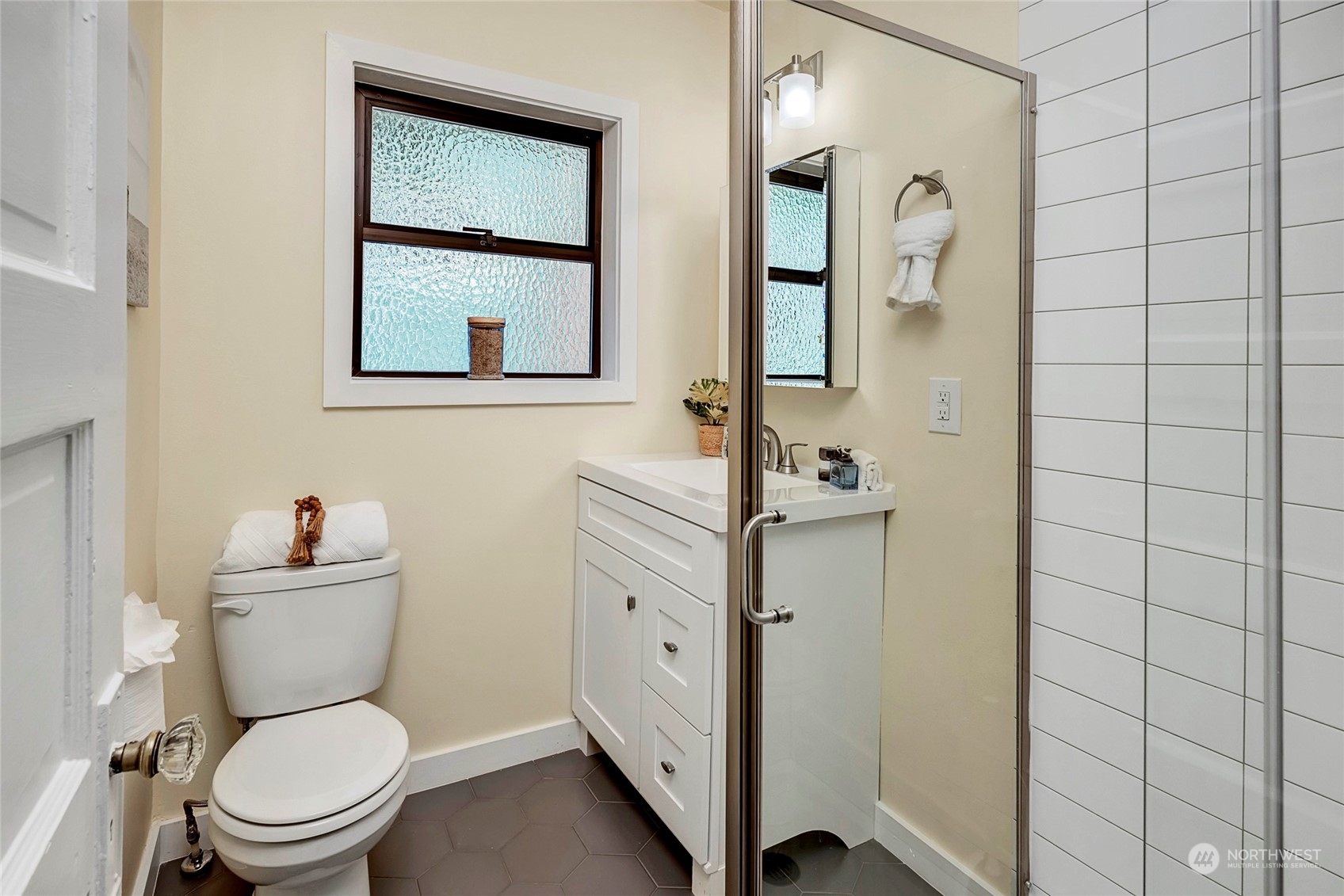 343 North 81st Street Seattle, WA 98103 - Photo 23 of 38 a bathroom with a toilet a sink and a mirror