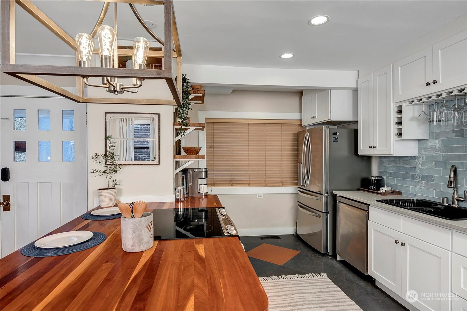 343 North 81st Street Seattle, WA 98103 - Photo 7 of 38 a kitchen with stainless steel appliances a refrigerator a sink dishwasher a stove and white cabinets with wooden floor