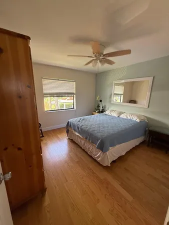 a bedroom with a bed chandelier and a window
