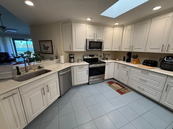 a kitchen with white cabinets sink and white appliances