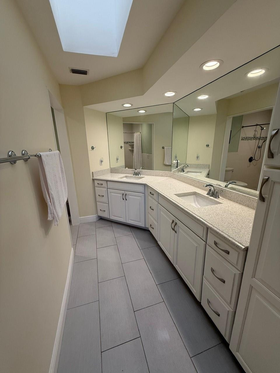 6102 Southeast Landing Way, Unit 13 Stuart, FL 34997 - Photo 10 of 14 a large bathroom with a granite countertop sink a mirror and a bathtub