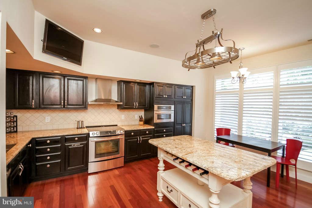 11560 Hemingway Drive Reston, VA 20194 - Photo 3 of 29 a kitchen with stainless steel appliances granite countertop a stove top oven a sink dishwasher and a microwave with wooden floor