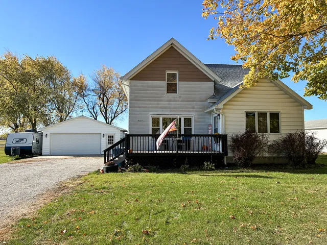 a front view of a house with a yard and trees