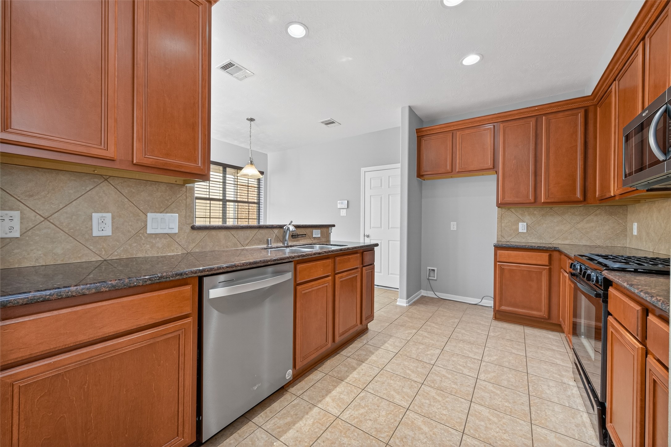 3646 Standing Rock Drive Spring, TX 77386 - Photo 6 of 30 a kitchen with stainless steel appliances granite countertop a stove a sink and a microwave