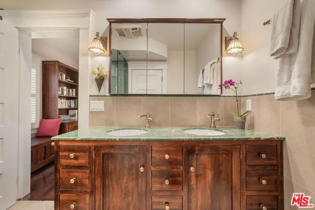 a bathroom with a granite countertop sink and a mirror