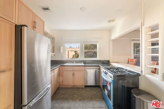 a kitchen with stainless steel appliances granite countertop a refrigerator and a sink