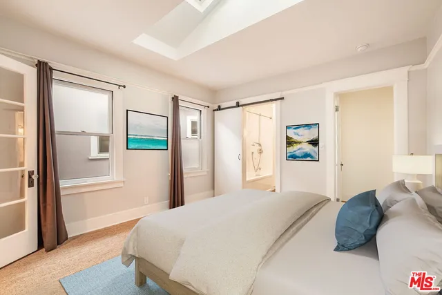 a bedroom with a large bed and a chandelier