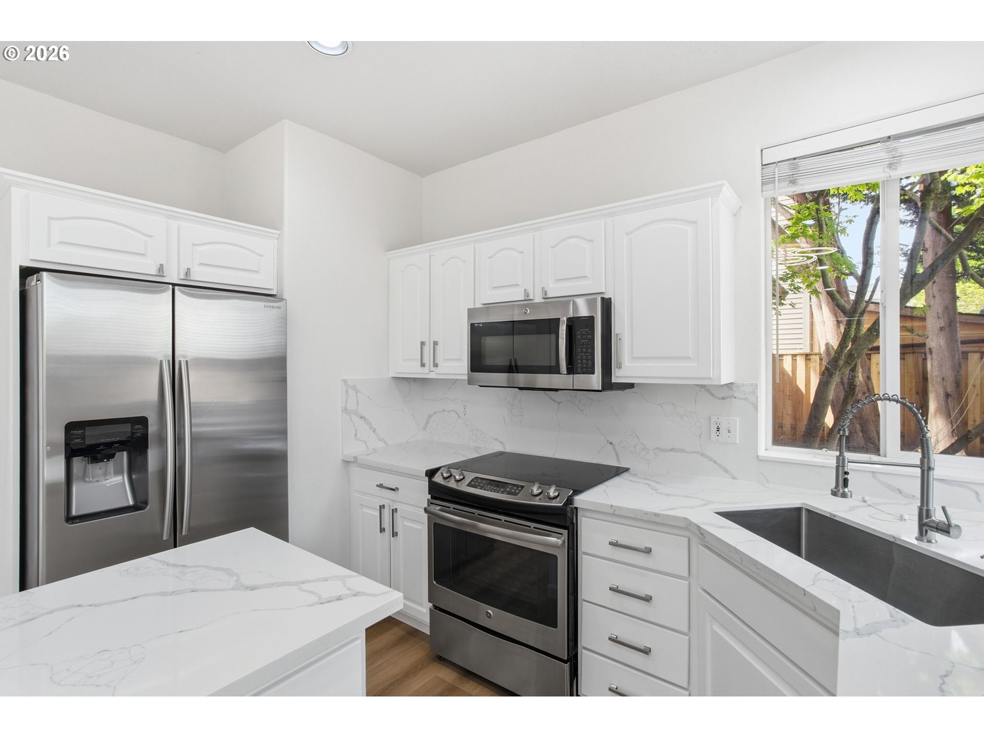 8911 Southwest Gravenstein Lane Tigard, OR 97224 - Photo 16 of 33 a kitchen with stainless steel appliances a stove a sink a refrigerator a window and a counter space