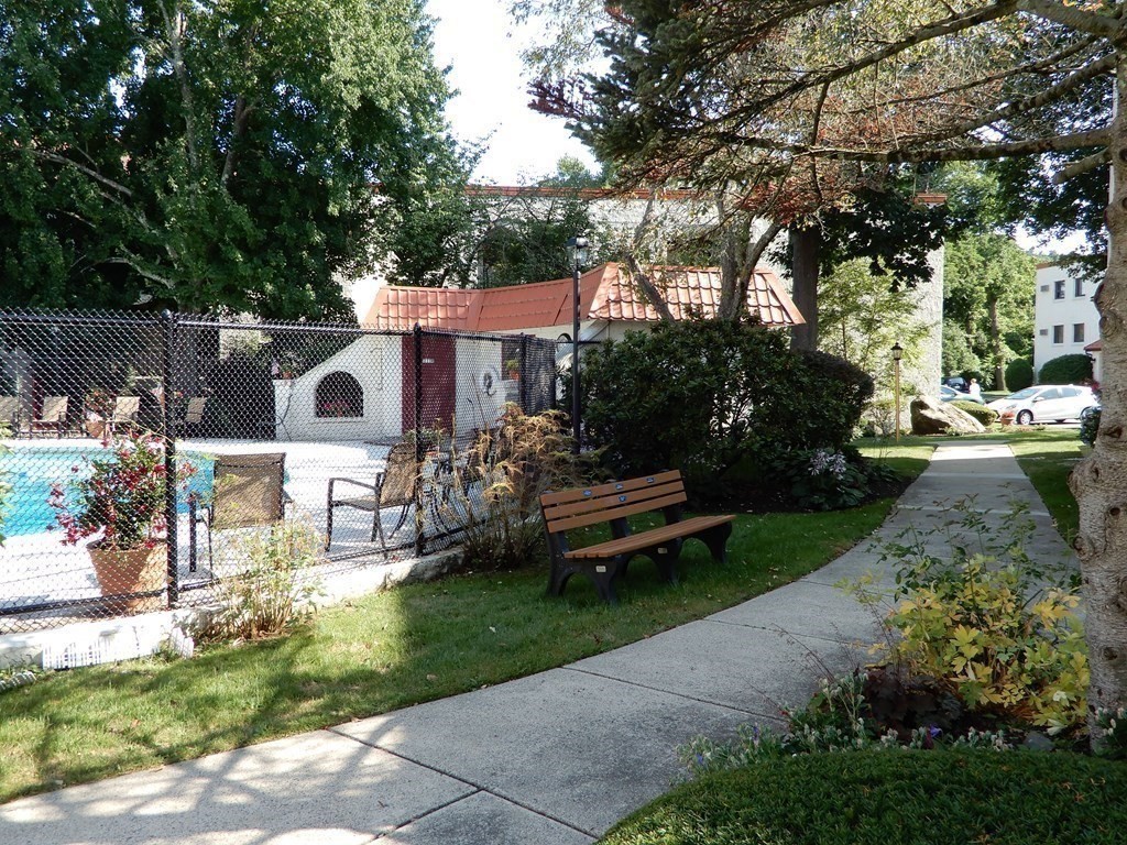 120 Fellsview Road, Unit 124 Stoneham, MA 02180 - Photo 17 of 20 a view of a patio with table and chairs potted plants and a large tree