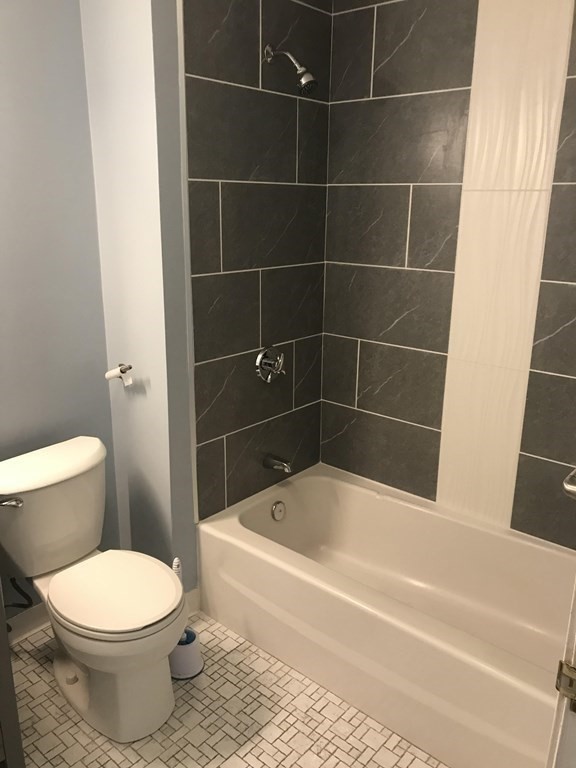 120 Fellsview Road, Unit 124 Stoneham, MA 02180 - Photo 9 of 20 a white toilet sitting next to a bath tub