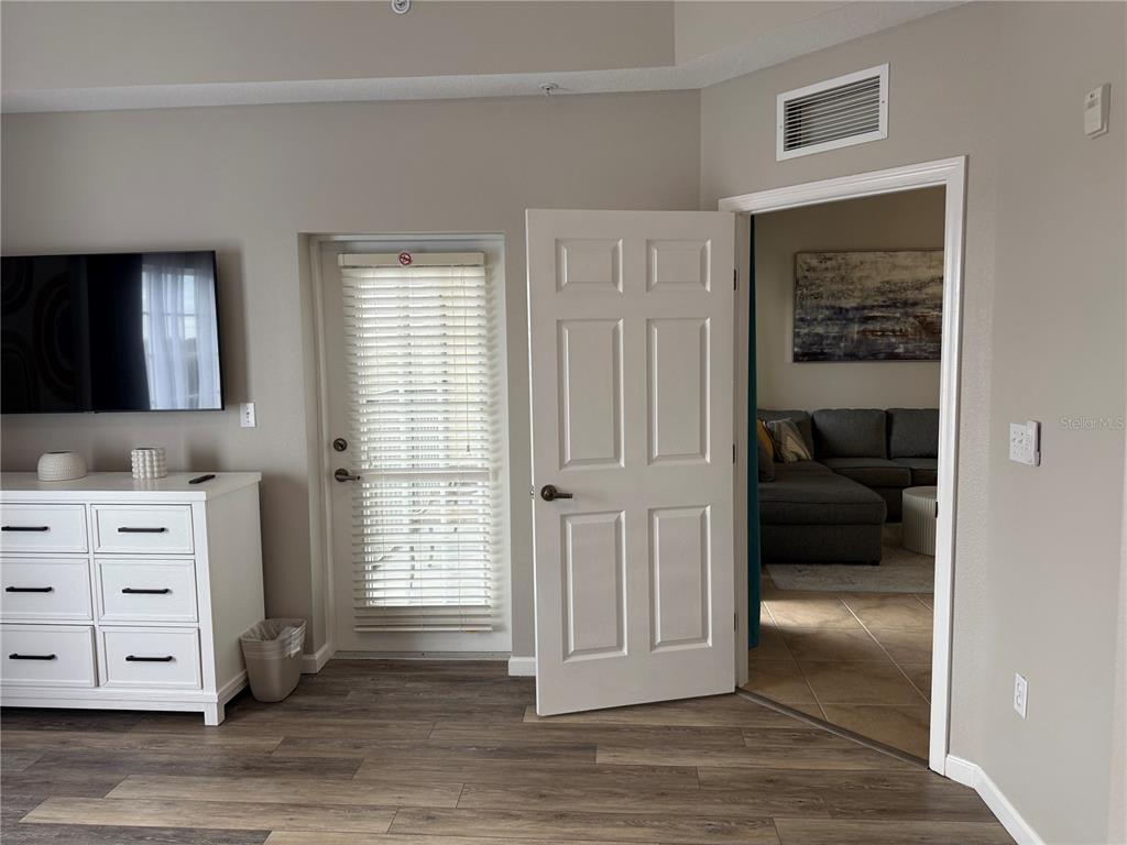 8762 Worldquest Boulevard, Unit 6504 Orlando, FL 32821 - Photo 12 of 45 a view of a bedroom with furniture and wooden floor