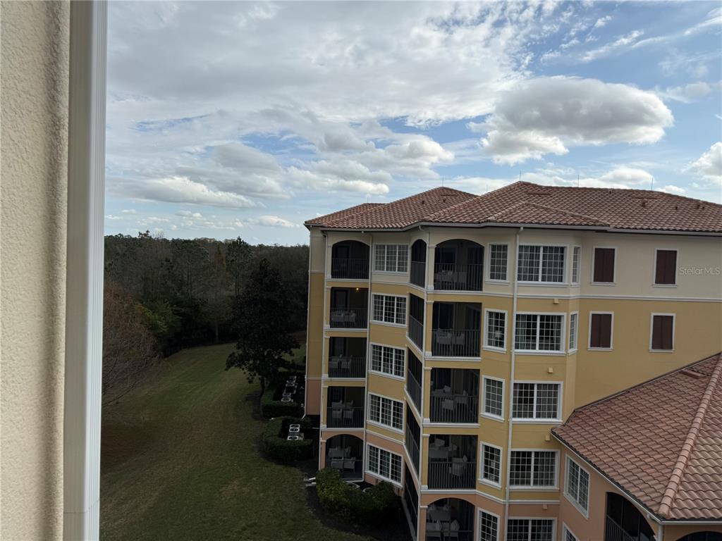 8762 Worldquest Boulevard, Unit 6504 Orlando, FL 32821 - Photo 14 of 45 a view of a large building next to a yard