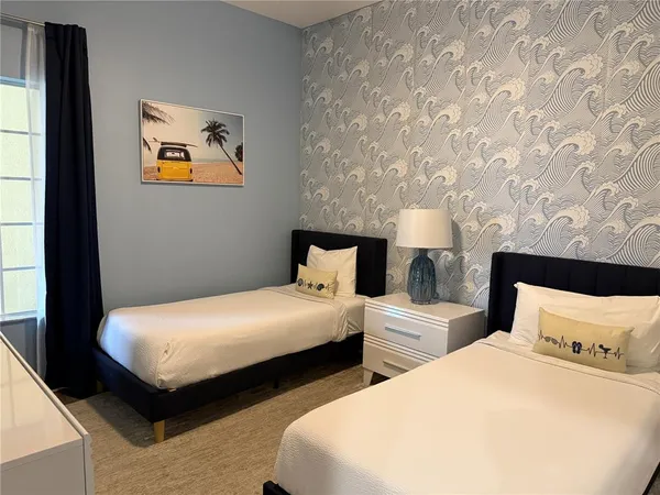a bedroom with two beds and painting on the wall