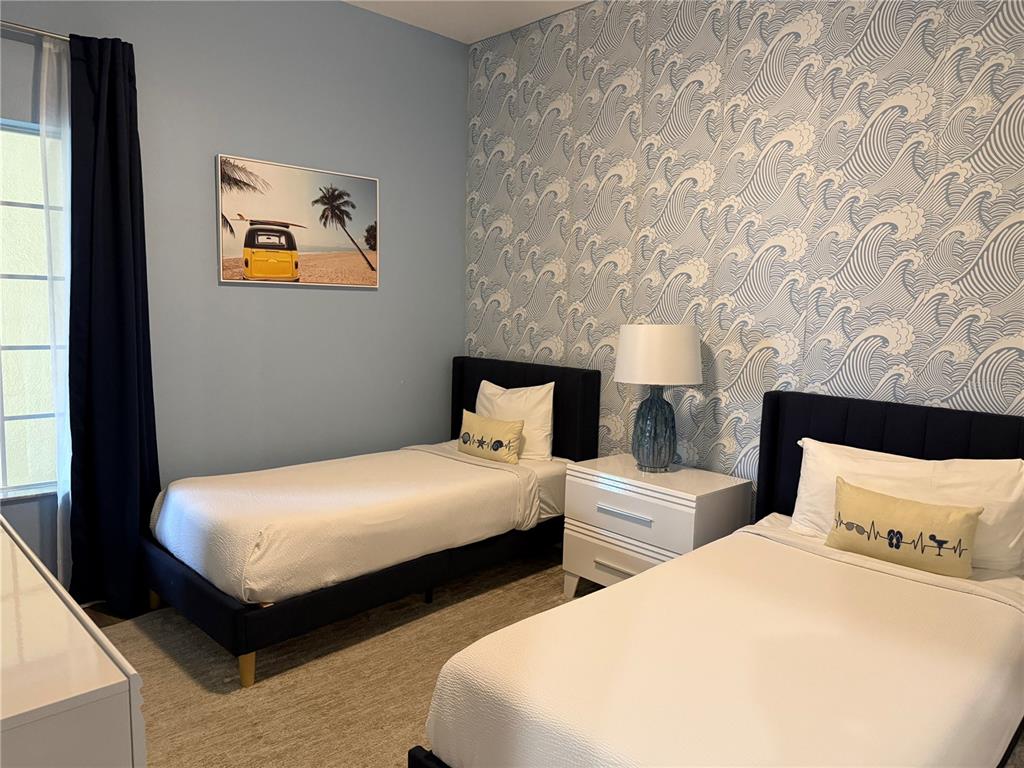 8762 Worldquest Boulevard, Unit 6504 Orlando, FL 32821 - Photo 30 of 45 a bedroom with two beds and painting on the wall