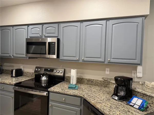 a kitchen with granite countertop a sink and cabinets