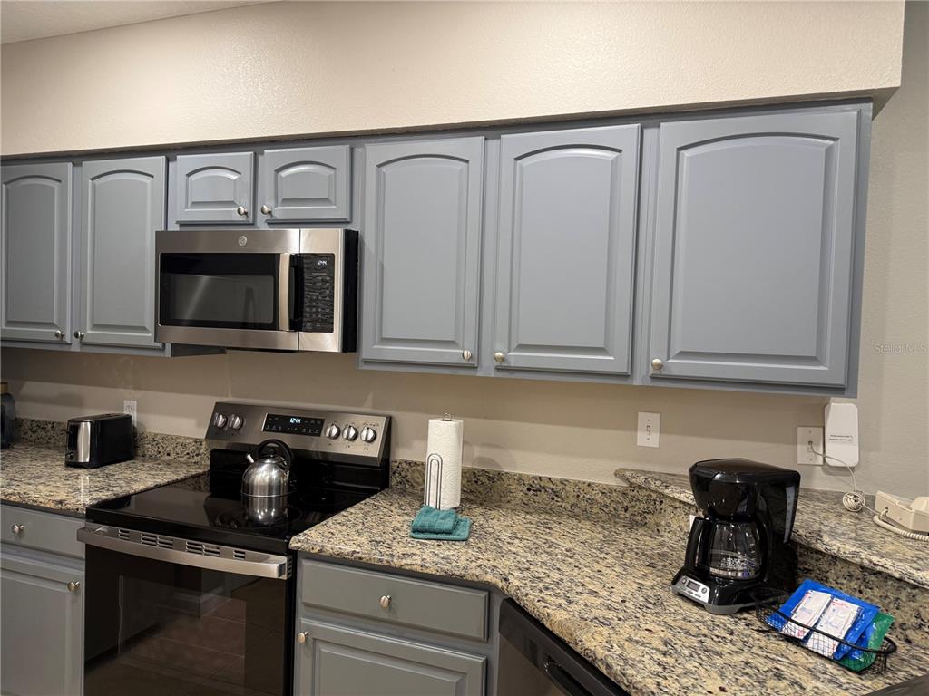8762 Worldquest Boulevard, Unit 6504 Orlando, FL 32821 - Photo 34 of 45 a kitchen with granite countertop a sink and cabinets