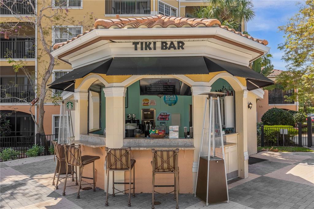 8762 Worldquest Boulevard, Unit 6504 Orlando, FL 32821 - Photo 42 of 45 a view of a cafe with a table and chairs under an umbrella