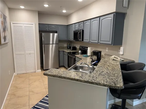 a kitchen with kitchen island granite countertop a refrigerator stove and sink