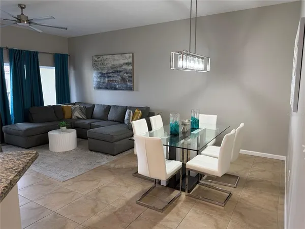 a living room with furniture a chandelier and a window