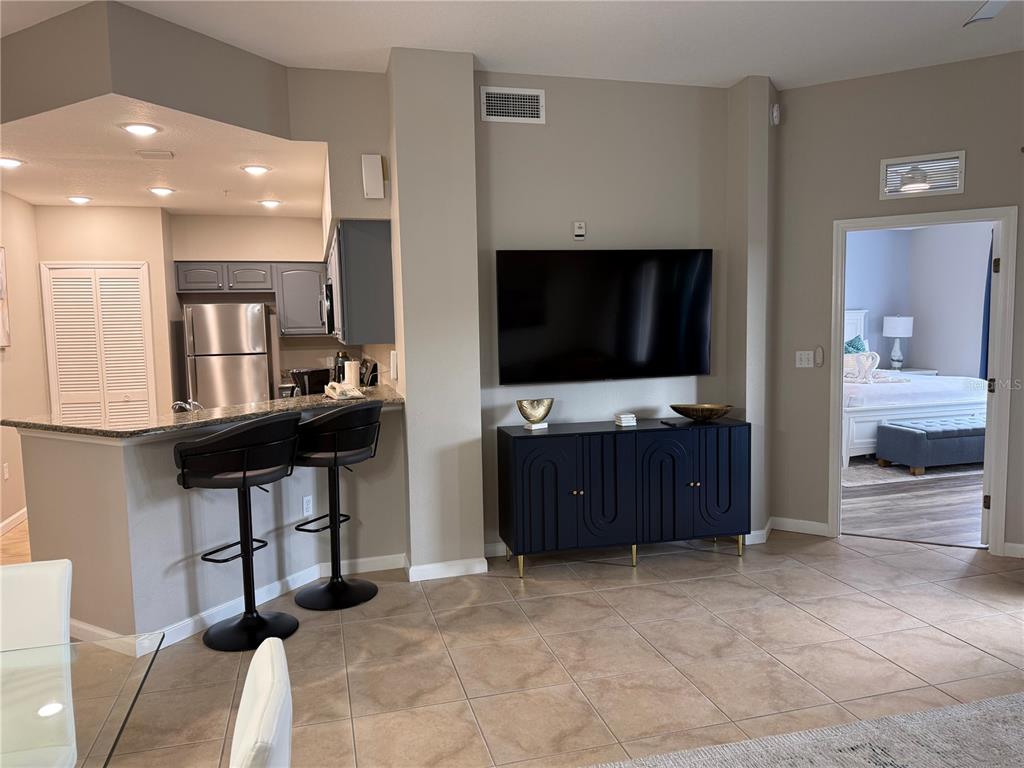 8762 Worldquest Boulevard, Unit 6504 Orlando, FL 32821 - Photo 8 of 45 a living room with furniture and a flat screen tv