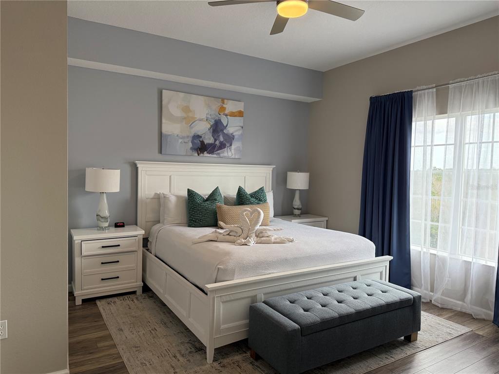 8762 Worldquest Boulevard, Unit 6504 Orlando, FL 32821 - Photo 10 of 45 a bedroom with a bed and a chandelier