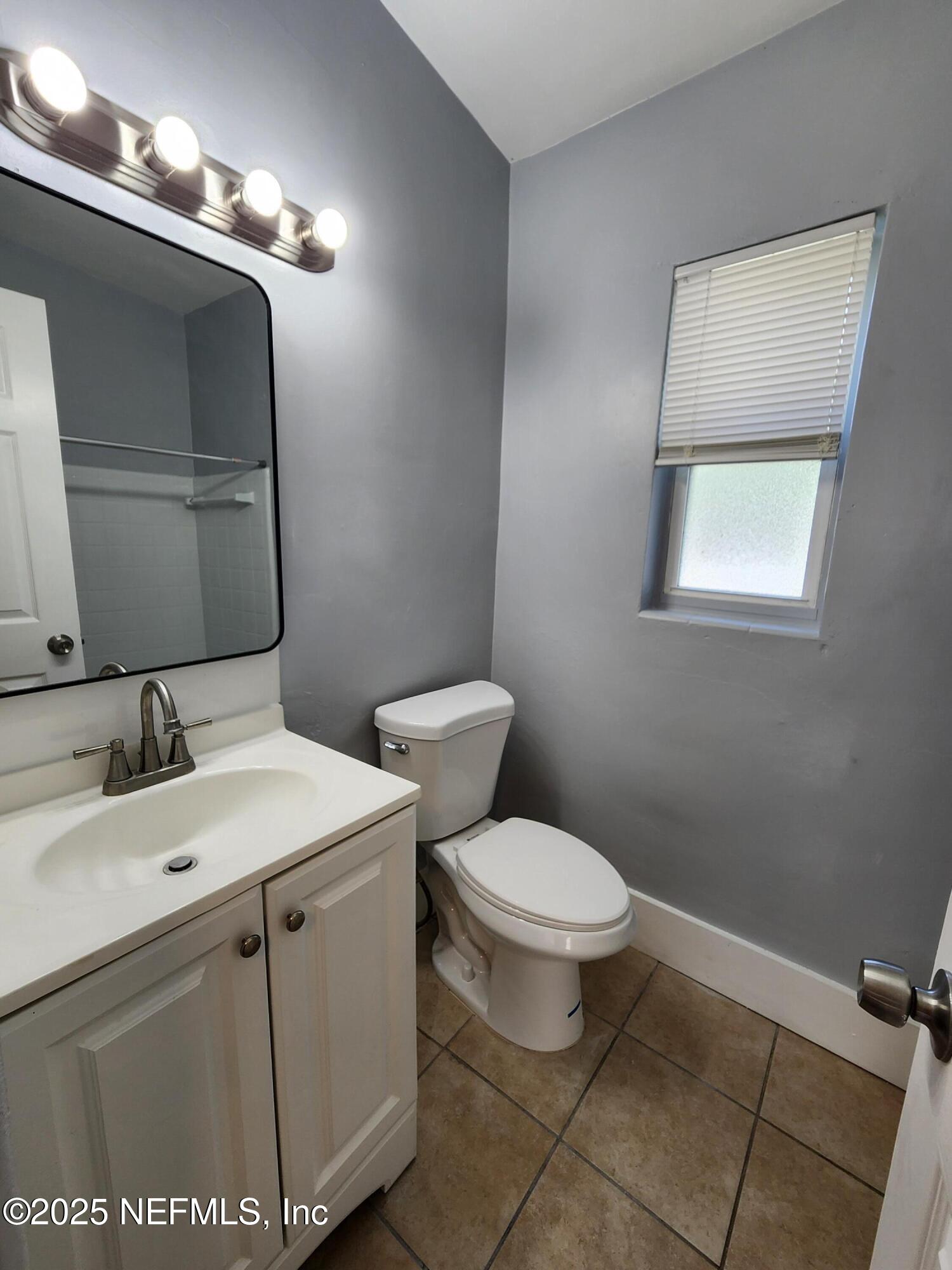 6151 Ardisia Road West Jacksonville, FL 32209 - Photo 12 of 18 a bathroom with a toilet sink and mirror