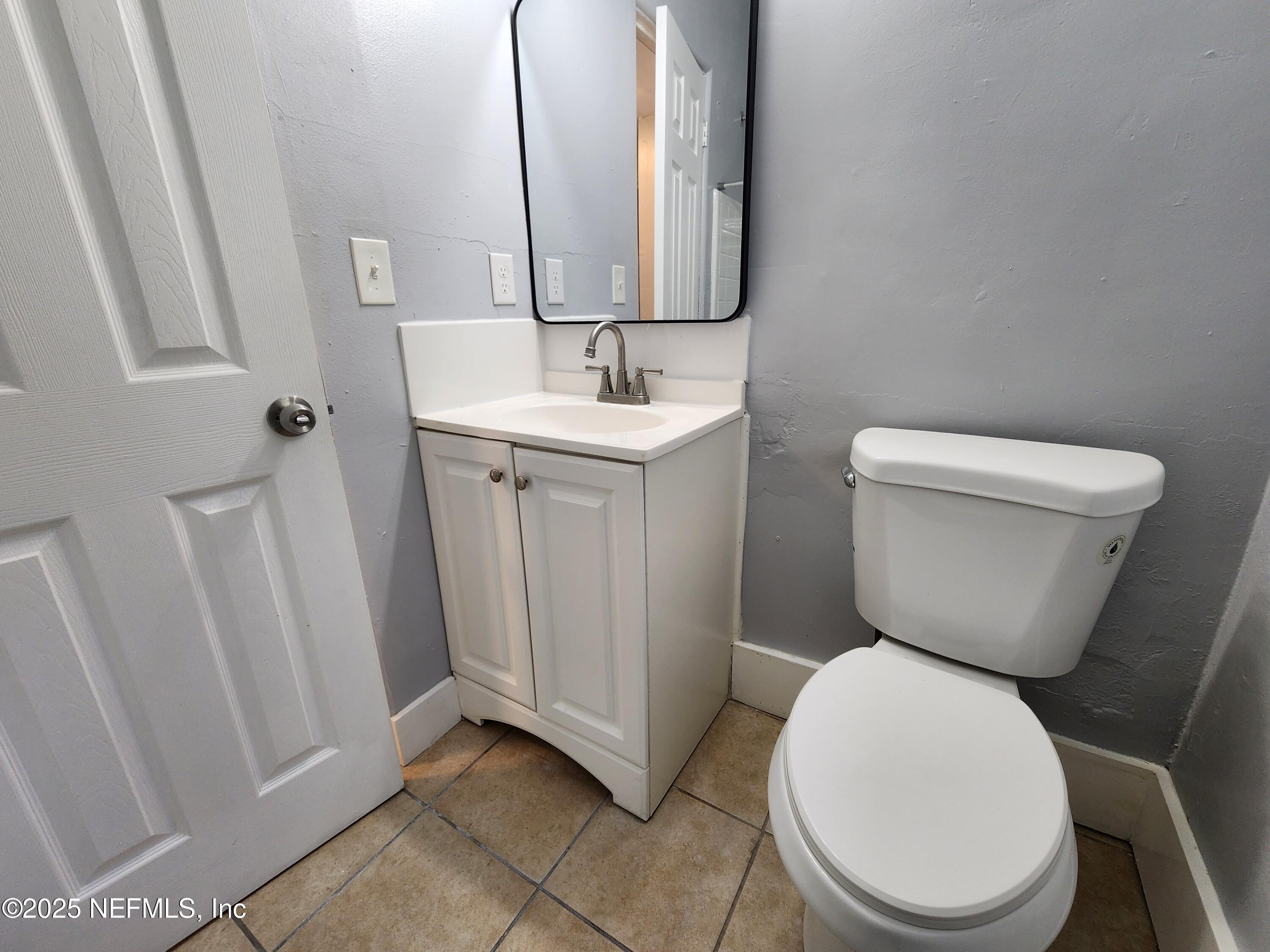 6151 Ardisia Road West Jacksonville, FL 32209 - Photo 13 of 18 a bathroom with a toilet sink and mirror