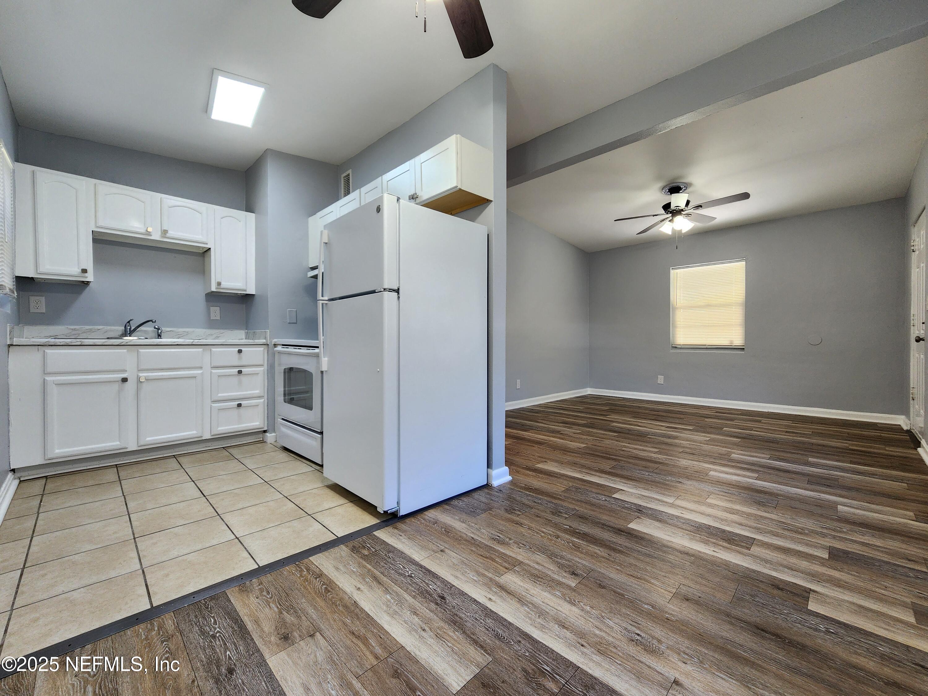 6151 Ardisia Road West Jacksonville, FL 32209 - Photo 6 of 18 a kitchen with a refrigerator a stove top oven a sink and cabinets