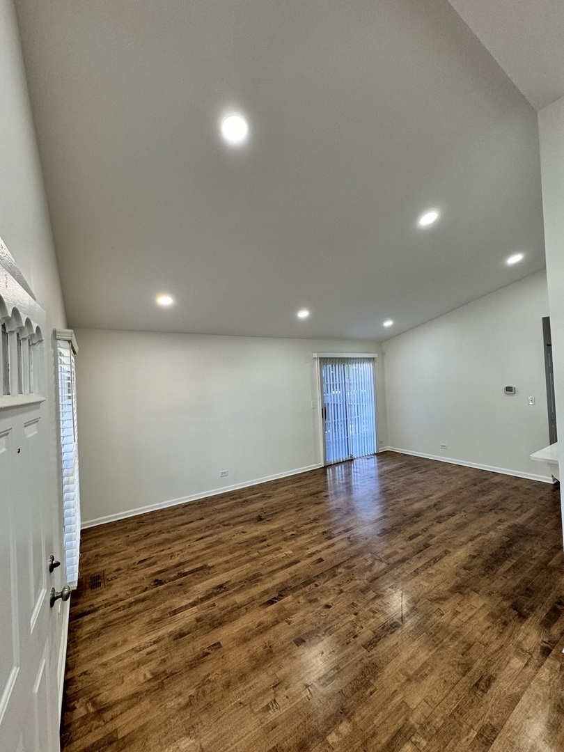 1944 Navarone Drive Naperville, IL 60565 - Photo 2 of 6 an empty room with wooden floor and windows