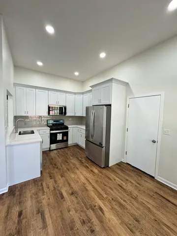 a kitchen with stainless steel appliances a refrigerator and a stove top oven