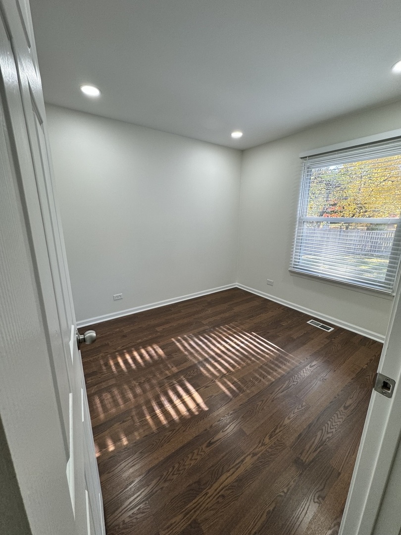 1944 Navarone Drive Naperville, IL 60565 - Photo 4 of 6 en empty room with wooden floor