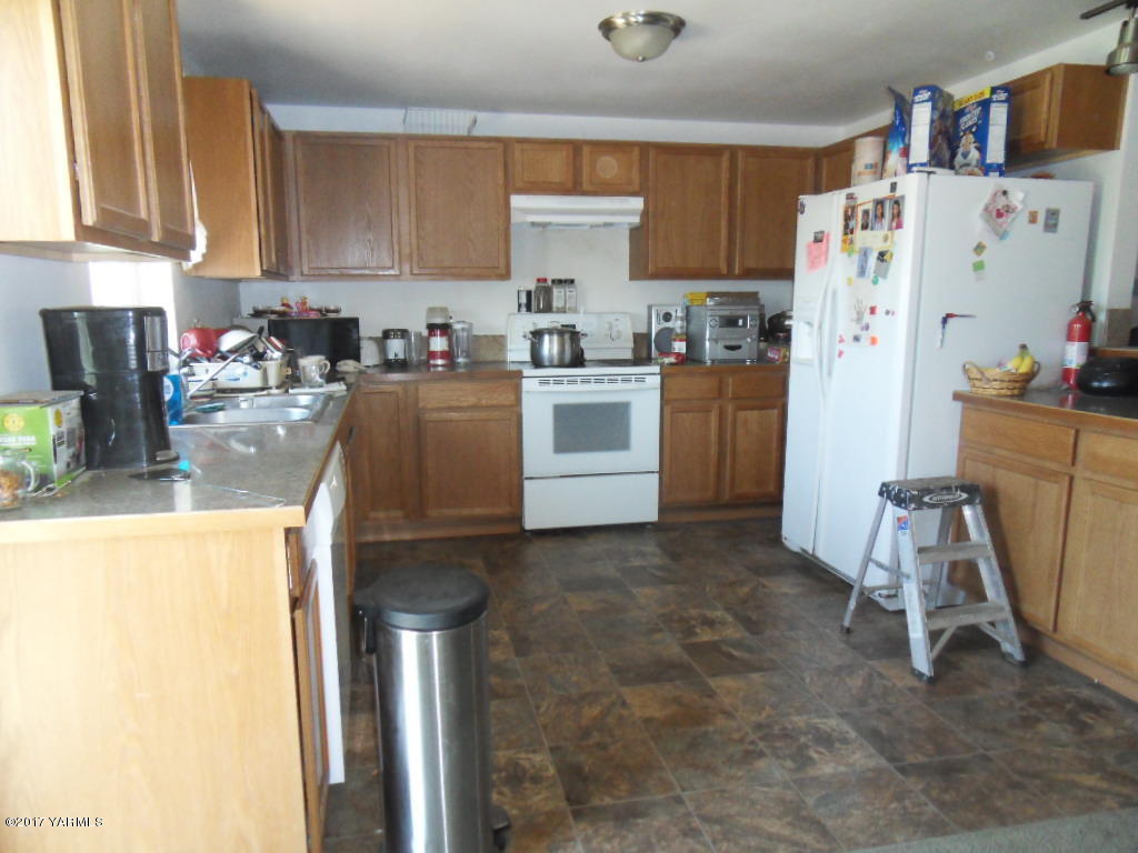 2708 Birchfield Road Yakima, WA 98901 - Photo 5 of 13 a kitchen with a refrigerator a stove a sink and cabinets