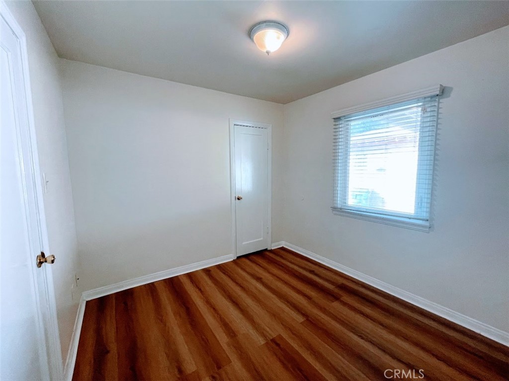 15334 Orizaba Avenue Paramount, CA 90723 - Photo 12 of 16 a view of an empty room with wooden floor and a window
