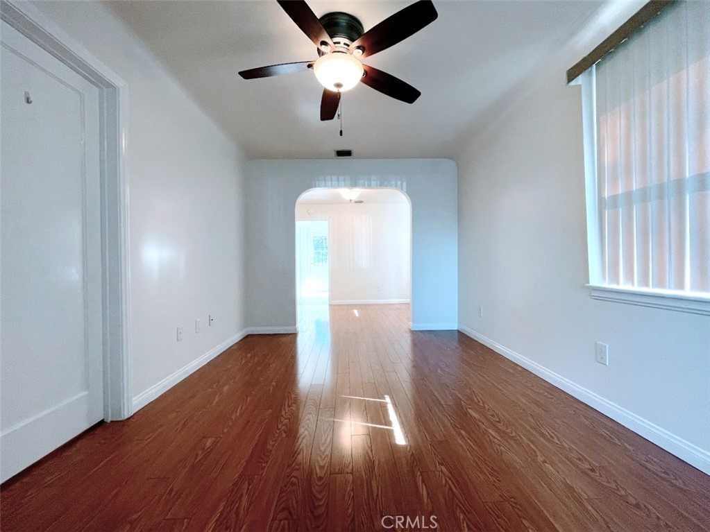 15334 Orizaba Avenue Paramount, CA 90723 - Photo 2 of 16 an empty room with wooden floor chandelier fan and windows