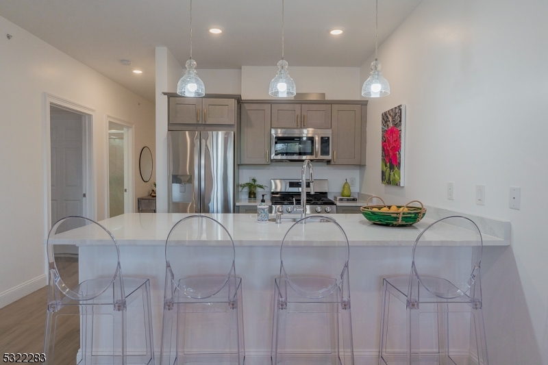 a room with stainless steel appliances kitchen island granite countertop furniture and a refrigerator