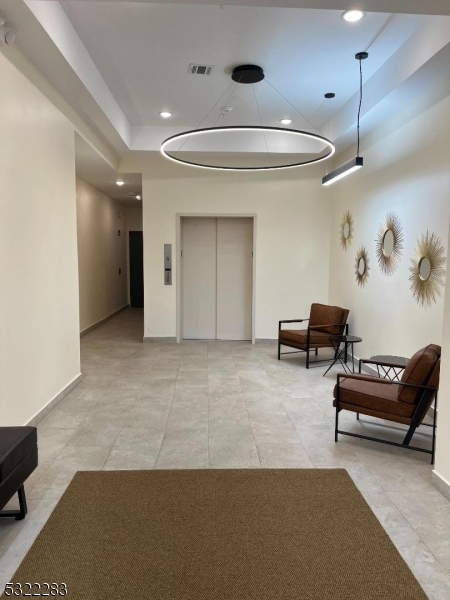 1026 Stuyvesant Avenue, Unit 403 Union, NJ 07083 - Photo 11 of 13 a living room with furniture and a chandelier