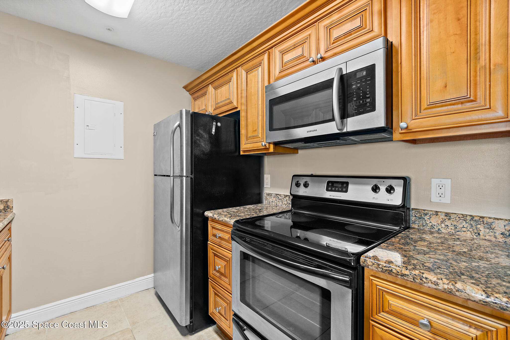 7667 North Wickham Road, Unit 222 Melbourne, FL 32940 - Photo 15 of 38 a kitchen with stainless steel appliances granite countertop a stove and a microwave