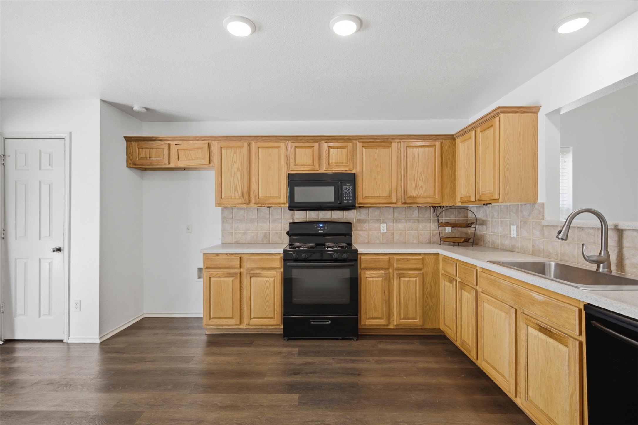 1416 Roxanne's Run Pflugerville, TX 78660 - Photo 13 of 35 A well-lit culinary space offers warm wood cabinetry and durable counters.
