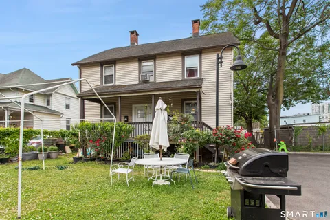 a view of a house with backyard sitting area and garden