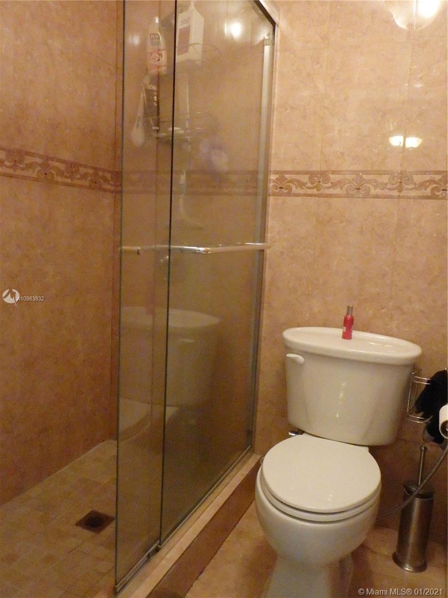 13735 Southwest 84th Street, Unit A Miami, FL 33183 - Photo 13 of 19 a white toilet sitting next to a bathroom shower