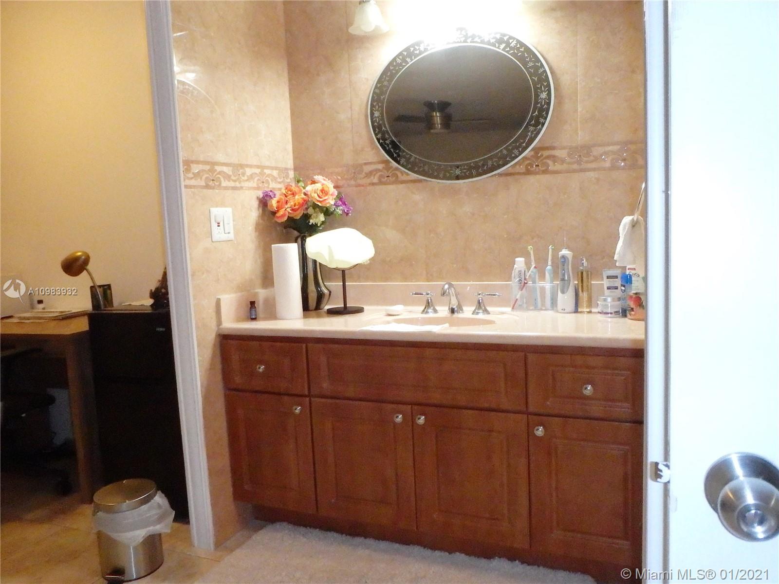 13735 Southwest 84th Street, Unit A Miami, FL 33183 - Photo 14 of 19 a bathroom with a sink and a mirror