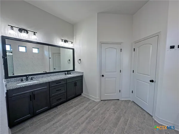 a spacious bathroom with a granite countertop sink and a mirror