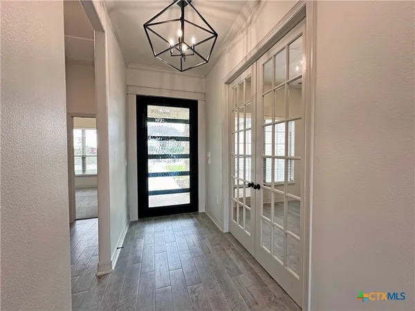 hallway with wooden floor and chandelier