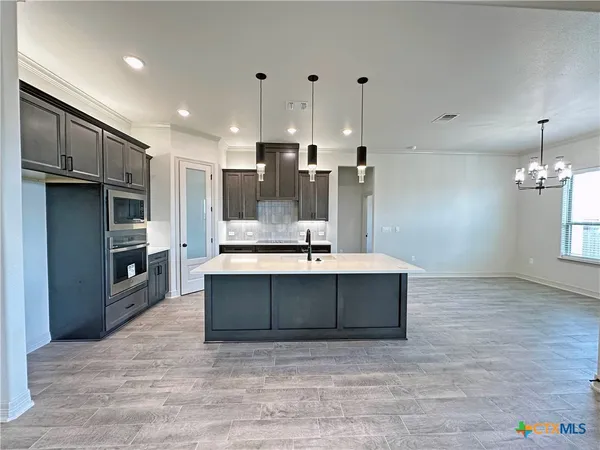 a view of kitchen with stainless steel appliances granite countertop cabinets and wooden floor